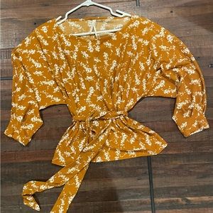 Anthropologie Amber Dolman copper orange colored blouse with a floral pattern.